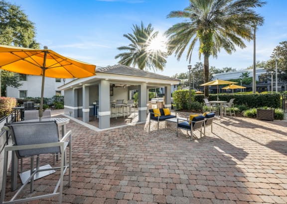 a patio with chairs and umbrellas and a house
