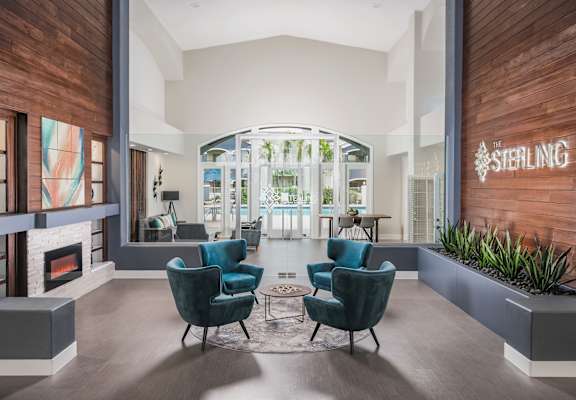 A living room with a fireplace and two chairs.