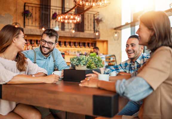 a group of people sitting around a table in a restaurant