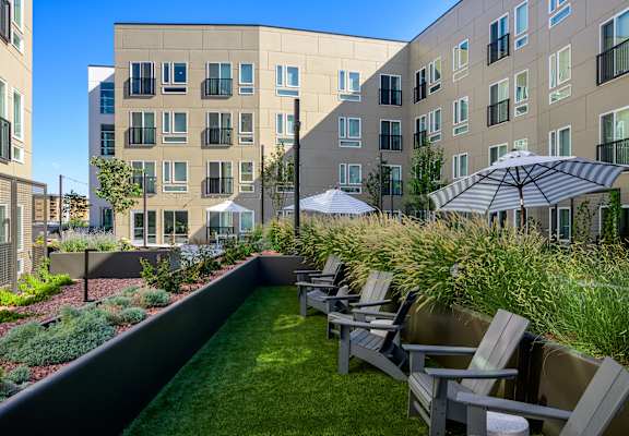 an outdoor seating area with chairs and a lawn