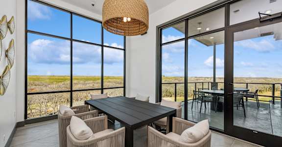 A modern dining room with a large table and chairs.