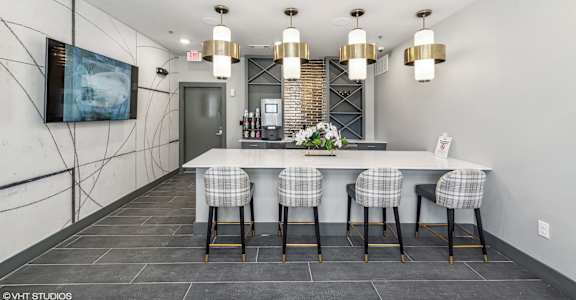 A kitchen with a bar area and a painting on the wall.