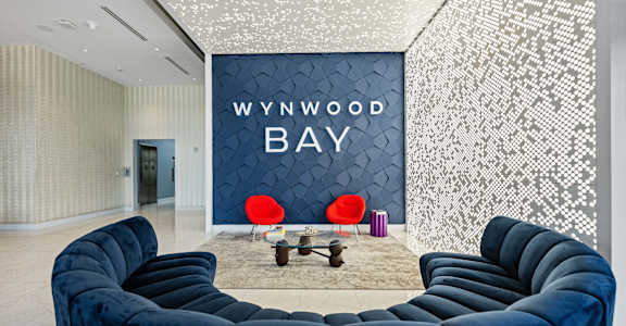 a living room with blue couches and a wall with a www wood