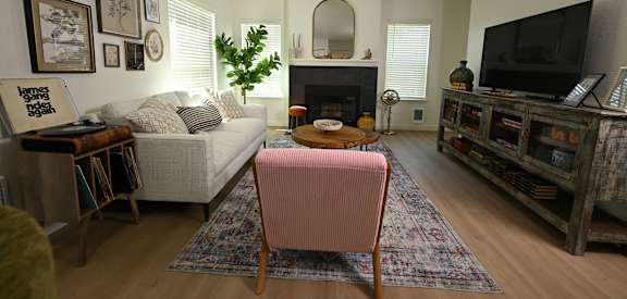 A living room with a pink chair in the center.