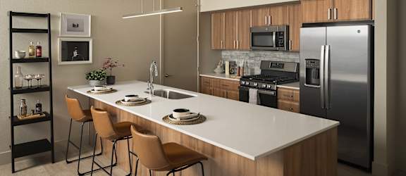 A modern kitchen with a white countertop and stainless steel appliances.