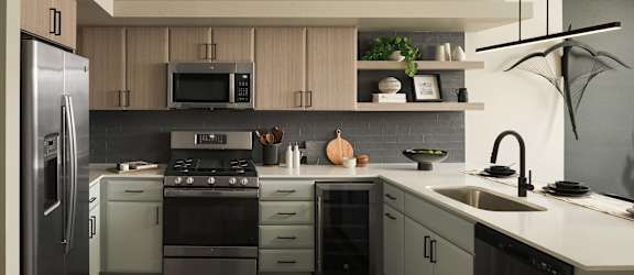 A modern kitchen with a refrigerator, stove, and sink.