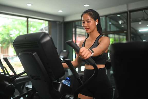 A woman is working out on a stationary bike in a gym.