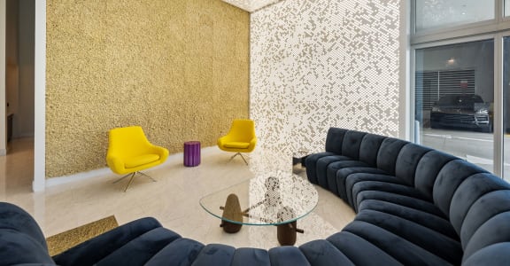 a living room with gold wallpaper and blue couches