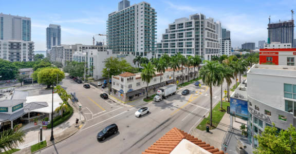 an aerial view of a city street with tall buildings and palm trees