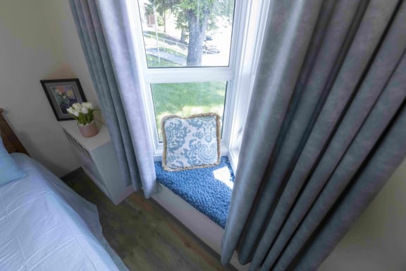 a window seat with a blue and white pillow