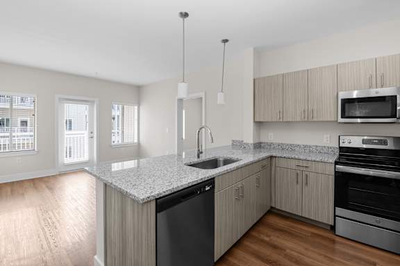 A kitchen with a granite countertop and stainless steel appliances.