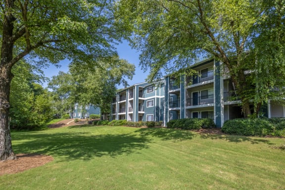 an apartment building with green grass and trees
