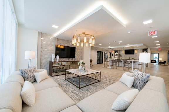 A modern living room with a large white sofa and a chandelier.