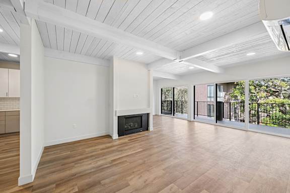A spacious living room with a fireplace and sliding glass doors.