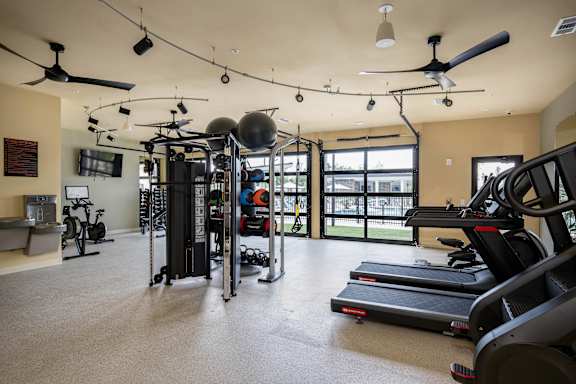 a gym with treadmills and other exercise equipment and a window