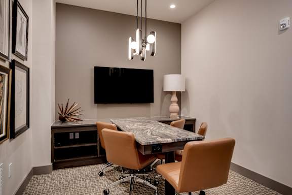 a conference room with a table and chairs and a tv