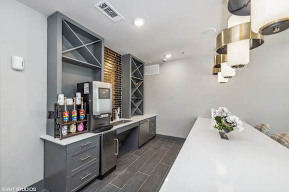 A modern kitchen with a white countertop and stainless steel appliances.