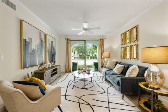 a living room with a couch and chairs and a ceiling fan