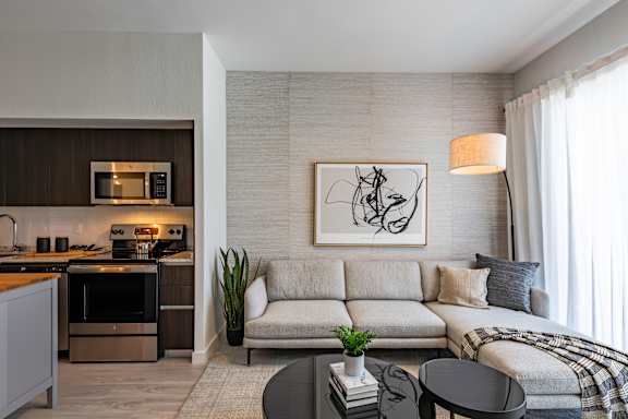 A modern living room with a grey sofa and a black coffee table.