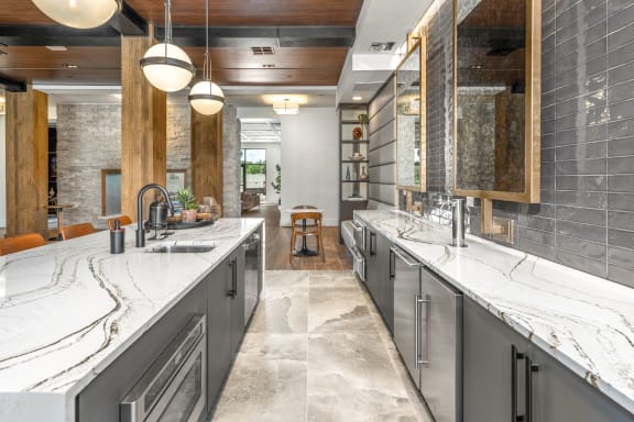 a large kitchen with two sinks and marble counter tops at The Haven at Lake Britt Apartments, Winter Garden, FL 34787