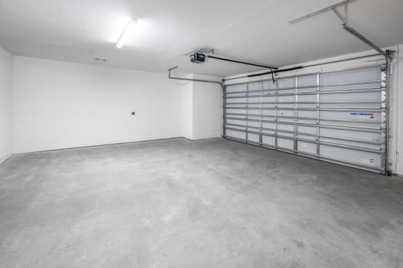 the interior of a garage with a metal garage door at The Haven at Lake Britt Apartments, Winter Garden, FL 34787