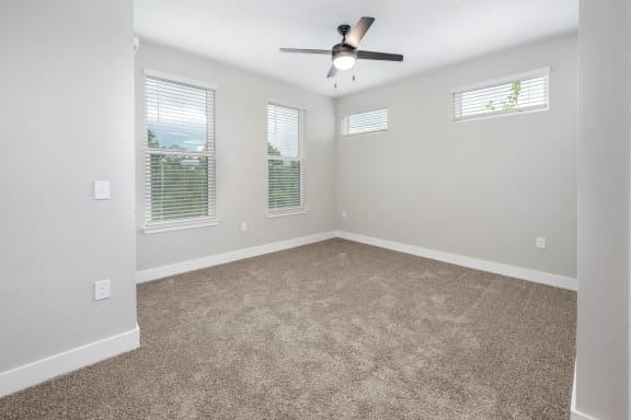 an empty living room with a ceiling fan and windows at The Haven at Lake Britt Apartments, Winter Garden, FL 34787