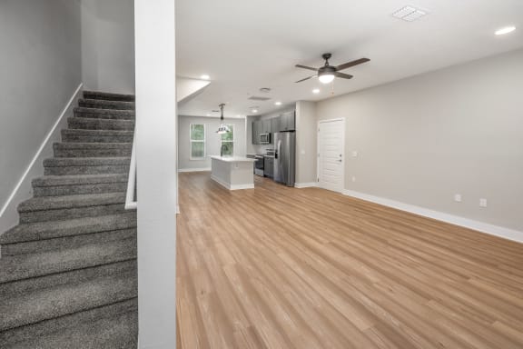 a living room with a staircase and a ceiling fan at The Haven at Lake Britt Apartments, Winter Garden, FL 34787