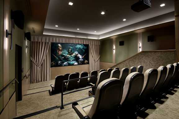 A row of black chairs are set up in front of a large screen.
