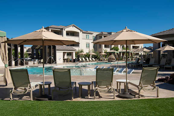 A poolside area with chairs and umbrellas.