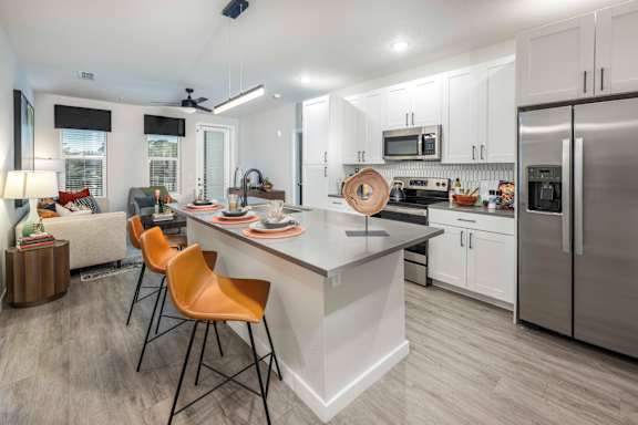 A modern kitchen with a white island and stainless steel appliances.