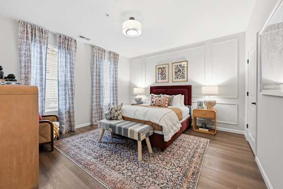 A bedroom with a bed, nightstand, and a rug. at Maison Apartments, Westerville, Ohio