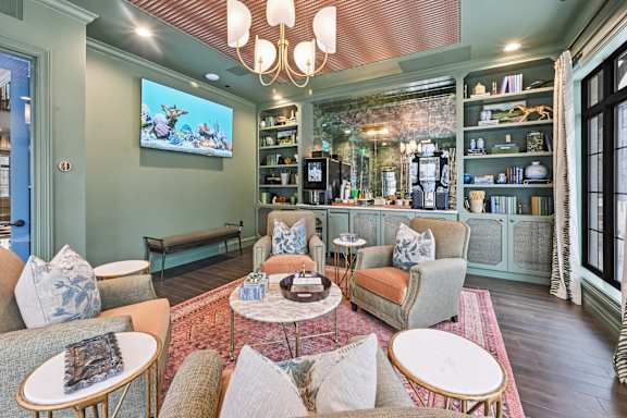 A living room with a large screen TV mounted on the wall. at Maison Apartments, Ohio, 43081