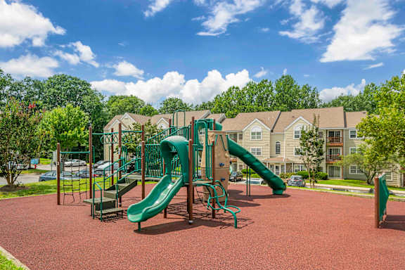  A playground with a green slide and red ground.