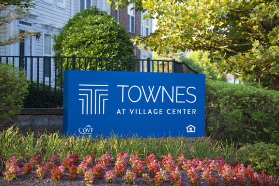 a row of townhouses in front of a brick building at Townes at Village Center Apartments, Maryland