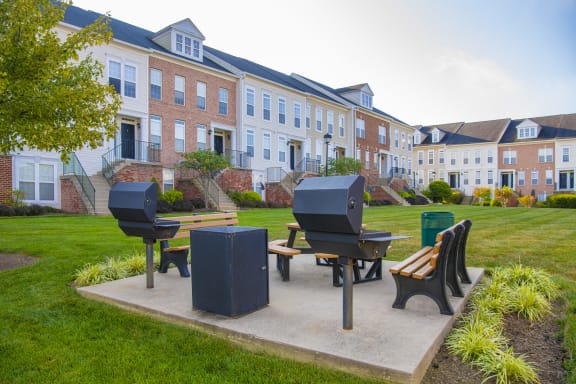 a group of people sitting around a table eating food at Townes at Village Center Apartments, Maryland