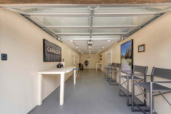 a long white table with chairs in a room with a vaulted ceiling