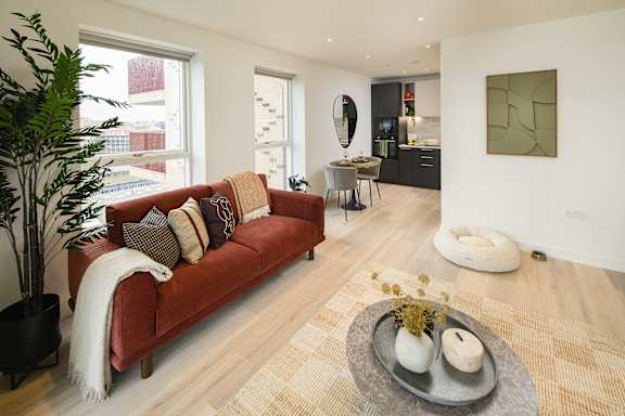 A living room with a red couch and a rug.