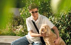 A man is sitting on a bench with his dog.