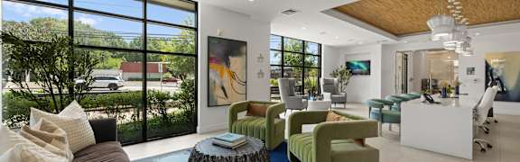 A modern living room with a brown couch and a blue rug.