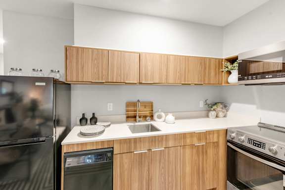 A modern kitchen with a stainless steel refrigerator, oven, and microwave.