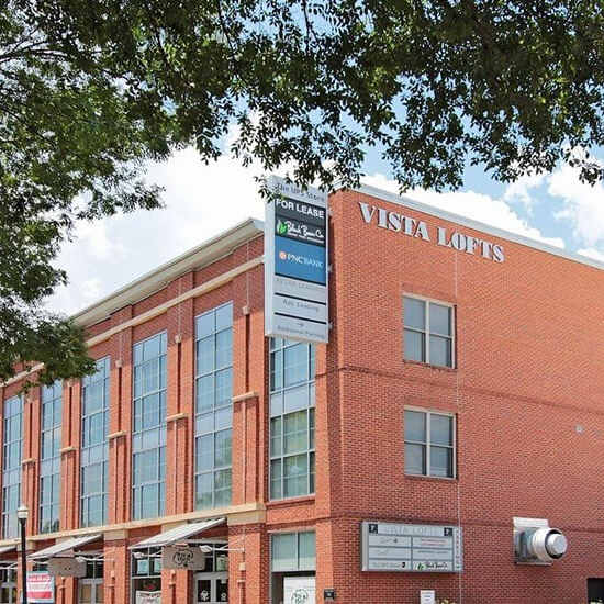 A red brick building with a sign that says Vista Lofts.