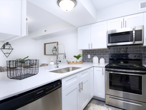 a kitchen with stainless steel appliances and white cabinets