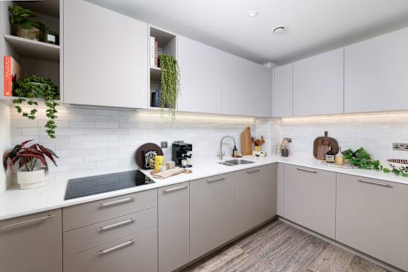 A kitchen with white cabinets and a wooden floor.