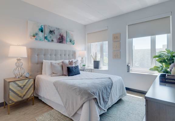 A bedroom with a large bed and a painting above it.