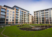Thumbnail 6 of 7 - an apartment building with a park in front of it