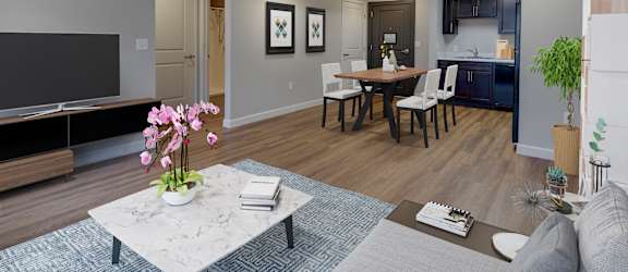 A modern living room with a dining table and chairs at Meadows Senior Living Apartments, New Hartford, NY, 13413