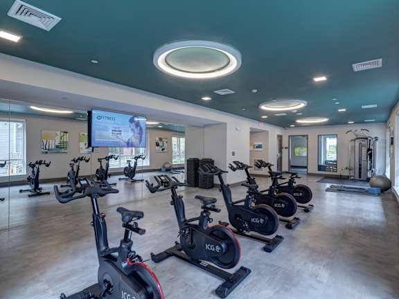 a fitness center with spin bikes and a tv