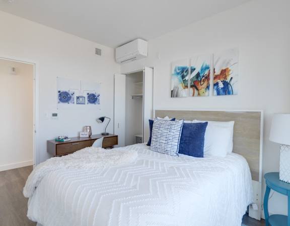 a bedroom with a white bed and blue and white pillows