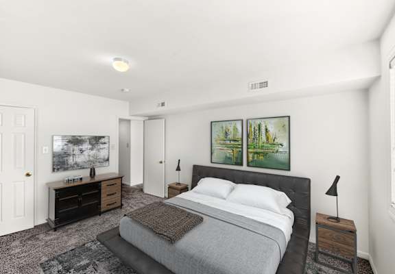 a white bedroom with a bed and two paintings on the wall
