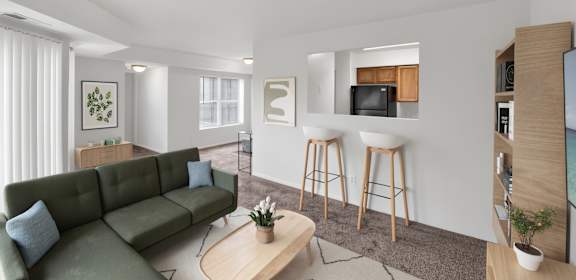 A living room with a green couch, a coffee table, and a bar area with stools.